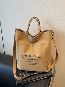 Large khaki canvas tote bag with top handle and shoulder strap for casual styling