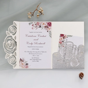 Detail of laser-cut rose wedding invitation with glitter card and floral inner page