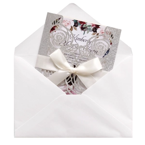 Detail of laser-cut glitter silver rose invitation set with floral insert and silk ribbon