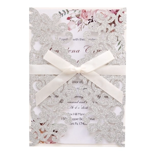 Silver glitter laser cut wedding invitation with elegant white ribbon and floral inner card