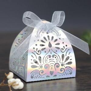 Detail of silver laser-cut wedding favor box with holographic finish and grey silk ribbon bow