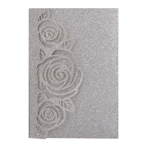 Close-up of glitter silver invitation card with embossed rose floral texture and sparkle