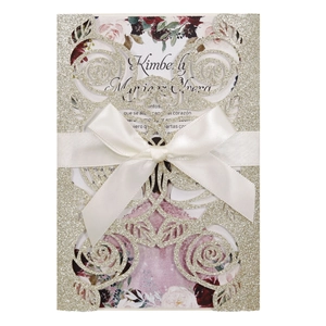 Golden glitter laser cut wedding invitation with white satin bow and floral details