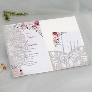 Detailed laser-cut silver glitter wedding invitation set with elegant floral motifs