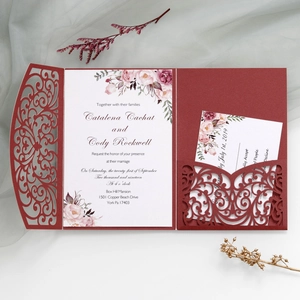 Detailed laser-cut pattern on burgundy wedding invitation with elegant floral insert cards