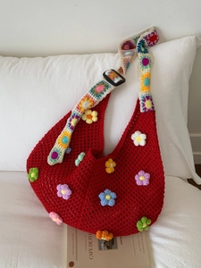 Handmade red crochet hobo bag with 3D floral accents and colorful wide shoulder strap