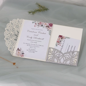 Detail of laser-cut floral wedding invitation with silver glitter insert and card