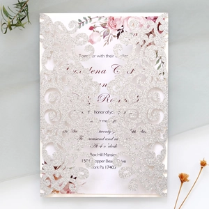 Detail of silver glitter laser cut wedding invitation with floral printed inner card