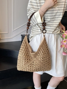 Handcrafted woven straw tote bag with geometric patterns and wooden bead straps for summer
