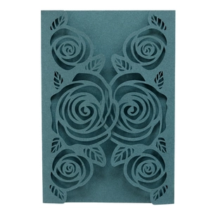 Detail of laser-cut rose patterns on dark teal pearlescent paper wedding invitation