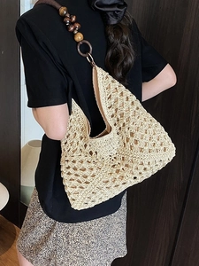 Beige woven straw hobo tote bag with bohemian wooden bead strap for beach vacation