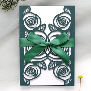 Detailed laser-cut rose pattern invitation with dark green ribbon and silk bow kit