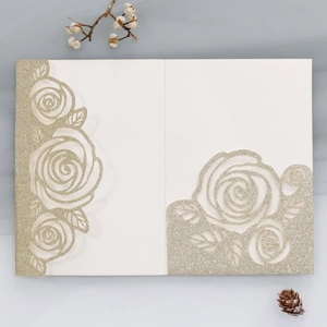 Macro view of white laser-cut rose patterns with light gold glitter on card edges