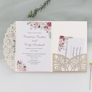 Detail of laser-cut glitter wedding invitation with floral insert and gold glitter card