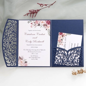 Macro detail of laser-cut navy blue wedding invitation with floral hollow-out pattern