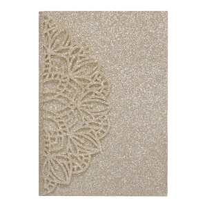 Detail of laser-cut lace floral pattern on champagne gold glitter wedding invitation