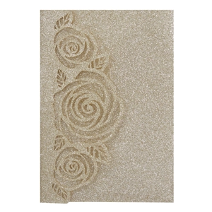 Macro detail of laser-cut rose relief on champagne gold glitter wedding invitation card