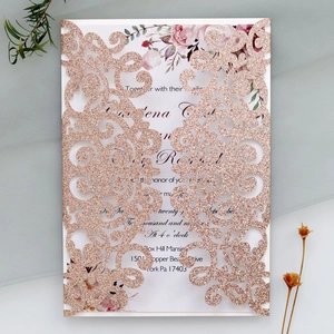 Detailed macro of rose gold glitter laser-cut wedding invitation with elegant floral insert