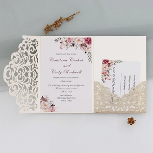 Detail of laser-cut lace wedding invitation with gold glitter pocket and floral insert