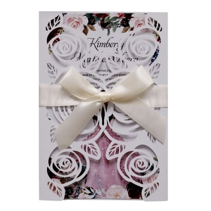 Laser cut rose wedding invitation with ivory ribbon and floral inner card on white background