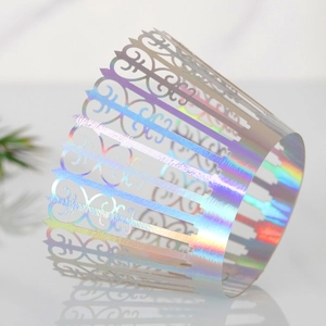 Detail of laser-cut holographic crown cake wrappers with iridescent floral lace patterns