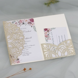 Detail view of laser-cut gold glitter wedding invitation with floral insert and RSVP card