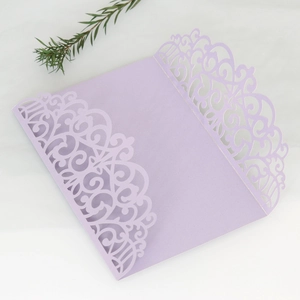 Macro detail of laser-cut floral pattern on lilac purple trifold wedding invitation cover