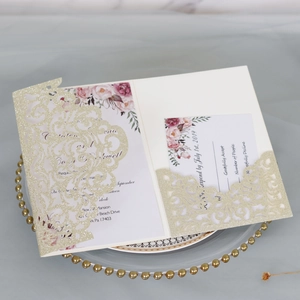 Detail of laser-cut glitter wedding invitation with floral insert and RSVP card