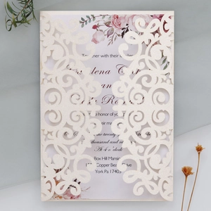 Detailed laser-cut wedding invitation featuring glitter cream paper and floral inner card