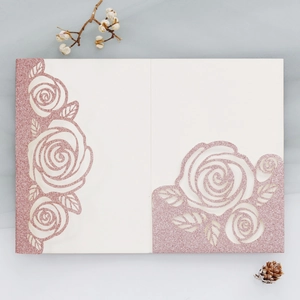 Macro detail of laser-cut rose patterns on pink glitter paper wedding invitations