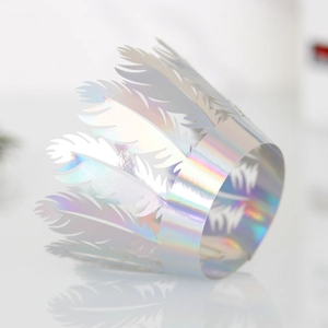 Detailed view of iridescent laser-cut crown cake wrappers with rainbow feather patterns