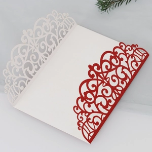 Macro detail of laser-cut glitter wedding card with red floral pattern and white inlay