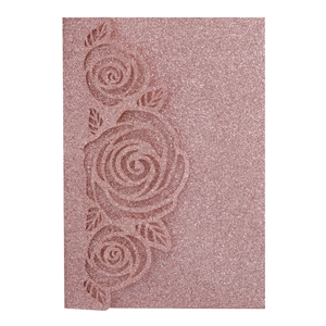 Detail of rose gold glitter wedding invitation featuring intricate laser cut rose patterns