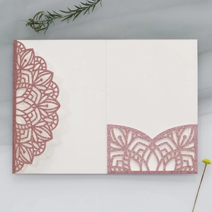 Detail of pink glitter laser cut wedding invitation with mandala pattern and cream insert