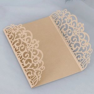 Intricate laser-cut champagne gold wedding invitation with floral pearlescent detail