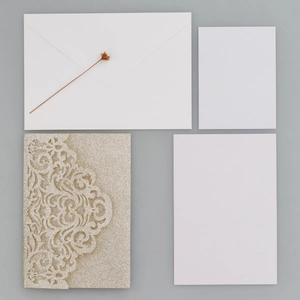 Detail der glitzernden lasergeschnittenen Hochzeitseinladung mit goldenem Hohlcover
