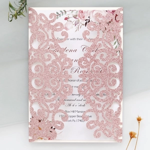 Detail of pink glitter laser-cut wedding invitation with elegant floral inner card