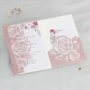 Close-up of laser-cut glittery pink rose hollow invite card with floral inner sheet