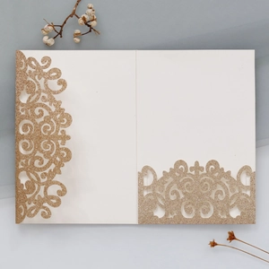 Dettaglio macro dell'invito di nozze glitterato oro con elegante intaglio laser a traforo