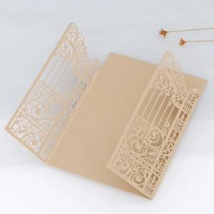 Detail of laser-cut champagne gold wedding invitation cover with floral filigree design