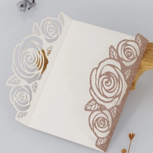 Detail of laser cut white rose wedding invitation with rose gold glitter coating