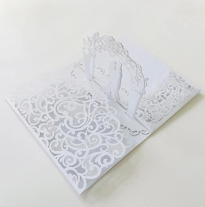 Macro detail of 3D laser-cut wedding invitation featuring romantic couple silhouette