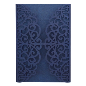 Close-up of laser-cut dark blue pearl paper wedding invitation with floral patterns