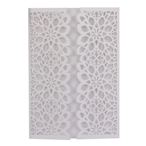Intricate laser-cut white wedding invitation sleeve with floral hollow patterns