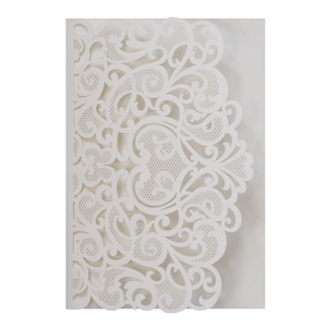 Detail of laser-cut white lace patterns on luxury wedding invitation with pearlescent finish