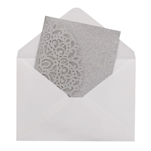 Silver glitter laser cut wedding invitation card with intricate lace pattern and white envelope