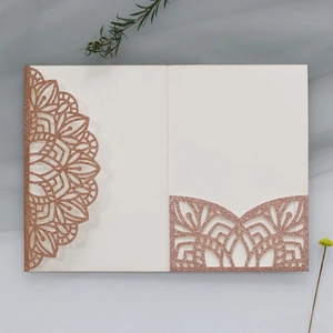 Detail of rose gold laser-cut wedding invitation with glitter finish and floral patterns