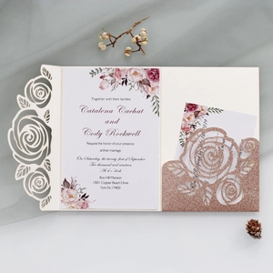 Detail of laser-cut wedding invitation with rose gold glitter flower pocket and floral card