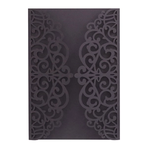 Detailed close-up of dark blue laser-cut wedding invitation with intricate floral patterns