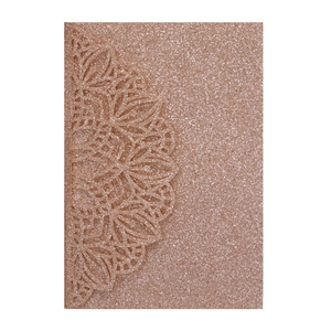 Close-up of rose gold laser-cut wedding invitation with intricate mandala patterns